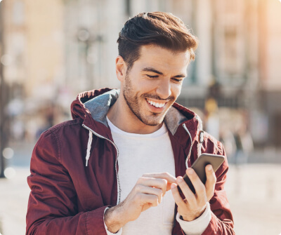 Young man smiling while looking at his phone